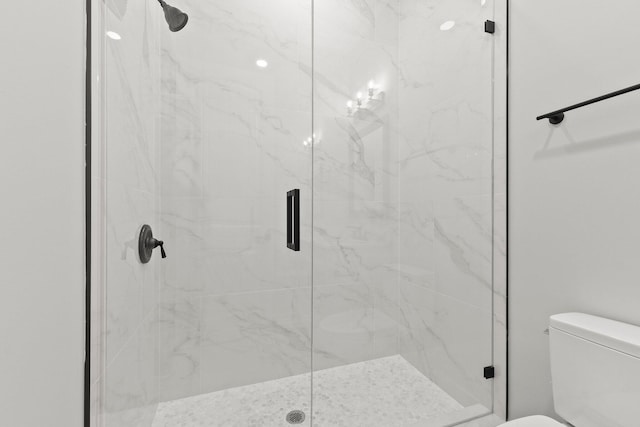 full bath featuring toilet and a marble finish shower