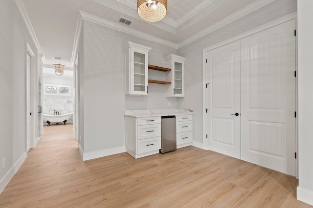 unfurnished office featuring light wood-style floors, visible vents, and crown molding