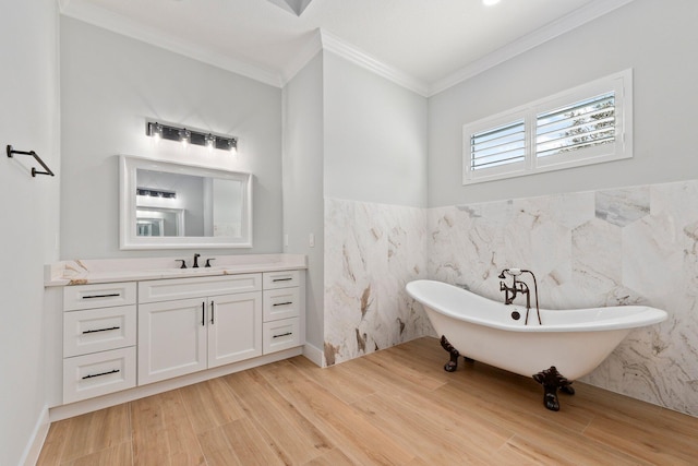 full bathroom with wainscoting, wood finished floors, crown molding, vanity, and a freestanding tub