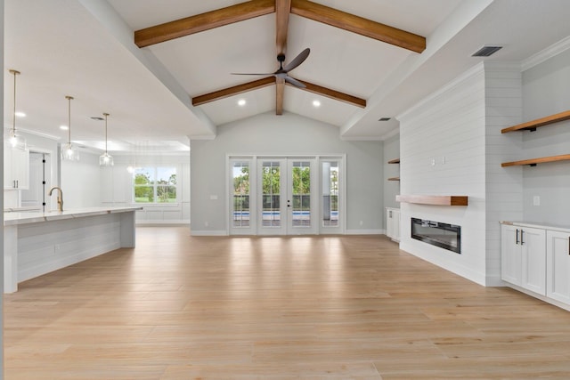 unfurnished living room with beam ceiling, visible vents, light wood-style flooring, a large fireplace, and high vaulted ceiling