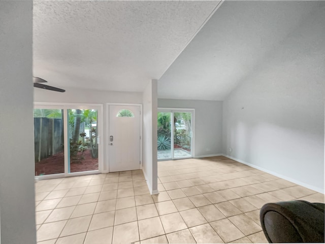 entrance foyer with light tile patterned floors, a textured ceiling, and a wealth of natural light