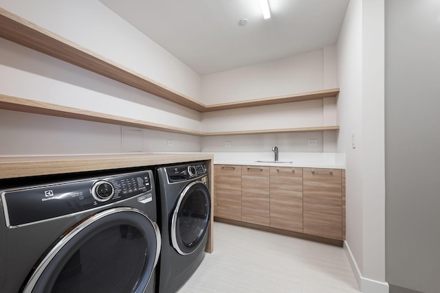 laundry area with laundry area, separate washer and dryer, a sink, and baseboards