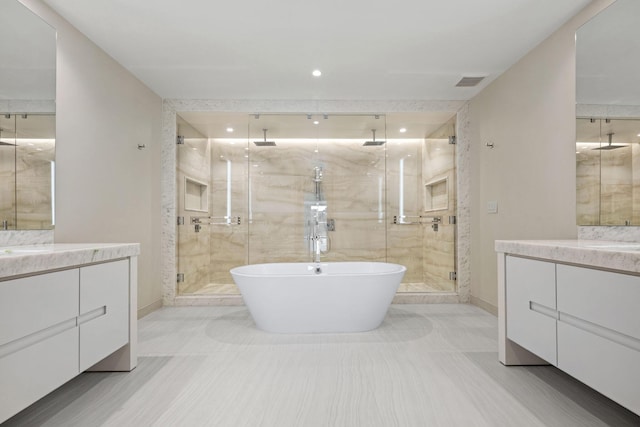 full bathroom with vanity, a soaking tub, a shower stall, and visible vents