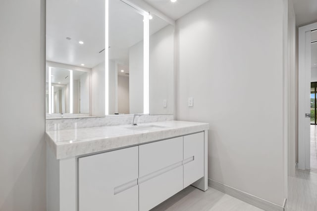 bathroom featuring recessed lighting, vanity, and baseboards