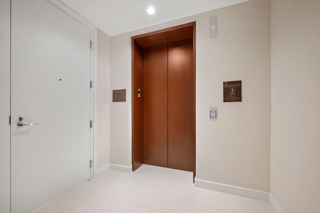 corridor featuring recessed lighting, elevator, and baseboards