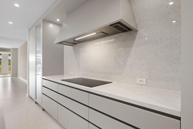 kitchen with custom range hood, backsplash, white cabinets, modern cabinets, and black electric cooktop