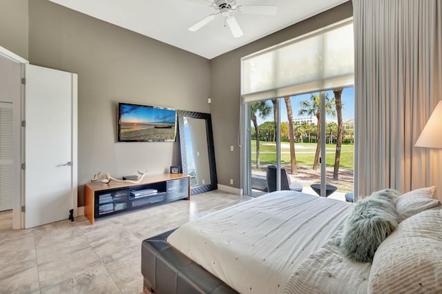 bedroom featuring access to exterior, ceiling fan, a high ceiling, and baseboards