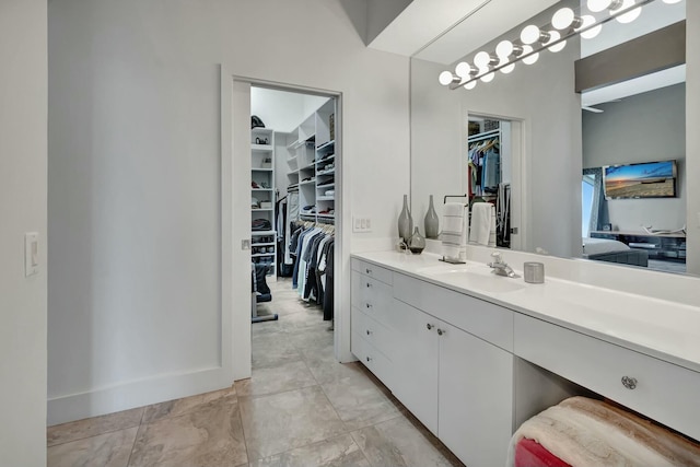 bathroom with a spacious closet and vanity