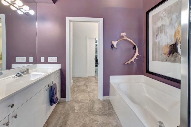 bathroom with a garden tub, baseboards, and vanity