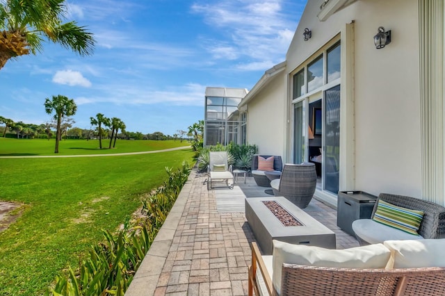 view of patio / terrace with an outdoor living space with a fire pit and a lanai