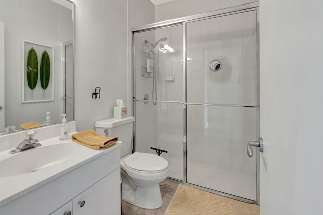 bathroom featuring a stall shower, vanity, and toilet