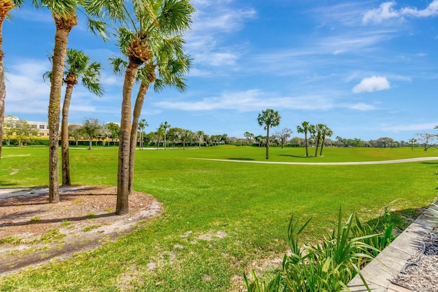 view of property's community with golf course view and a lawn