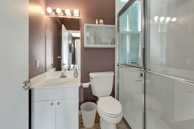 bathroom with toilet, a stall shower, and vanity