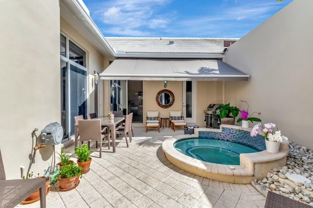 exterior space featuring outdoor dining area, a patio area, grilling area, and an in ground hot tub