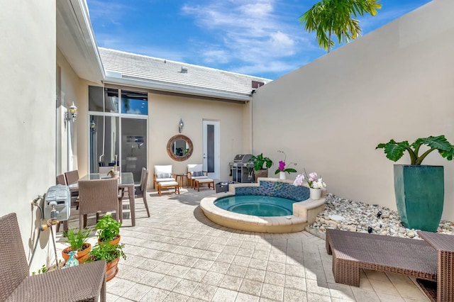 exterior space featuring a patio, outdoor dining area, area for grilling, and an outdoor hot tub