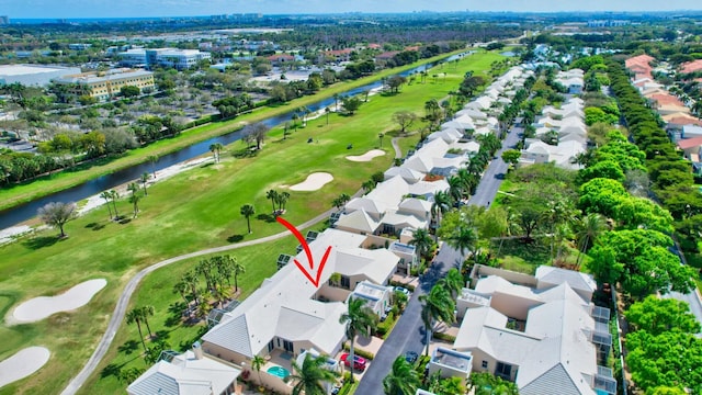 birds eye view of property featuring view of golf course, a water view, and a residential view