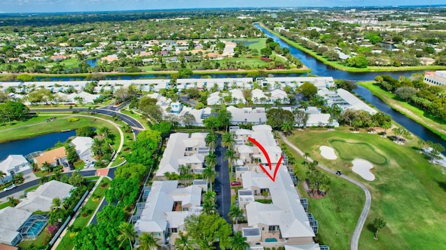 drone / aerial view featuring view of golf course, a water view, and a residential view