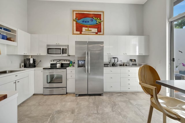 kitchen with white cabinetry, stainless steel appliances, and light countertops