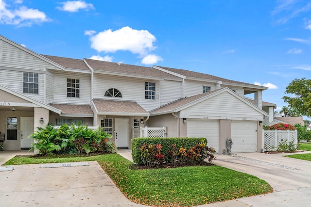 multi unit property featuring concrete driveway, roof with shingles, an attached garage, and stucco siding