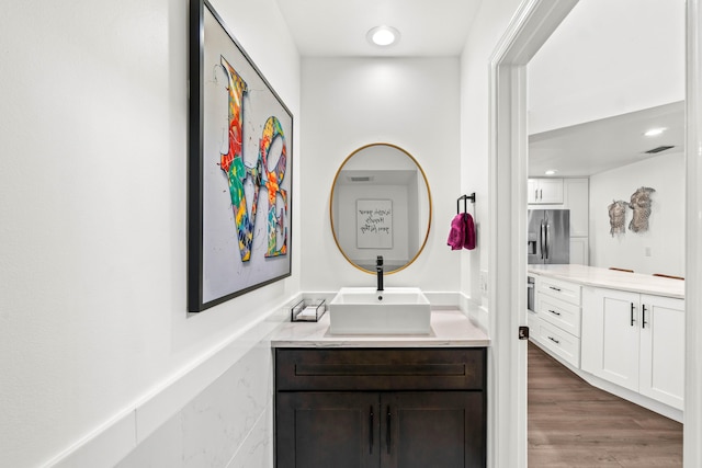 bathroom with visible vents, wood finished floors, and vanity