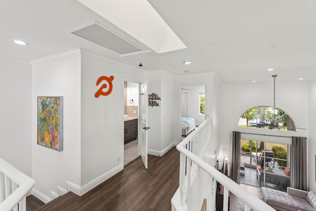 hall with baseboards, dark wood-type flooring, crown molding, an upstairs landing, and recessed lighting