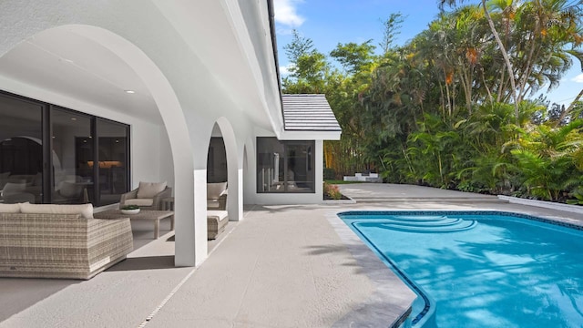 outdoor pool with a patio area and an outdoor hangout area