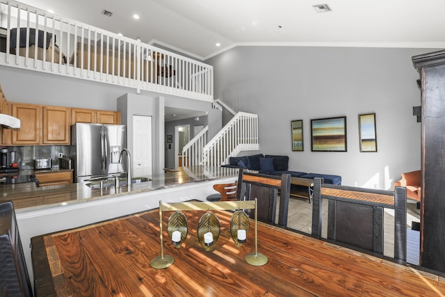 dining room with high vaulted ceiling, ornamental molding, stairway, and visible vents