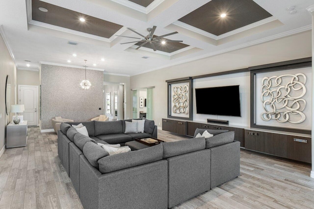 living area with light wood-style flooring, ceiling fan with notable chandelier, coffered ceiling, beam ceiling, and crown molding