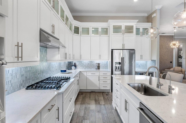 kitchen featuring white cabinets, glass insert cabinets, appliances with stainless steel finishes, pendant lighting, and a sink