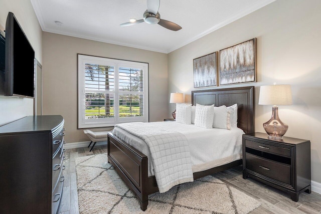 bedroom featuring light wood-type flooring, baseboards, ornamental molding, and a ceiling fan