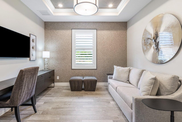 living room featuring light wood-style floors, a raised ceiling, and crown molding