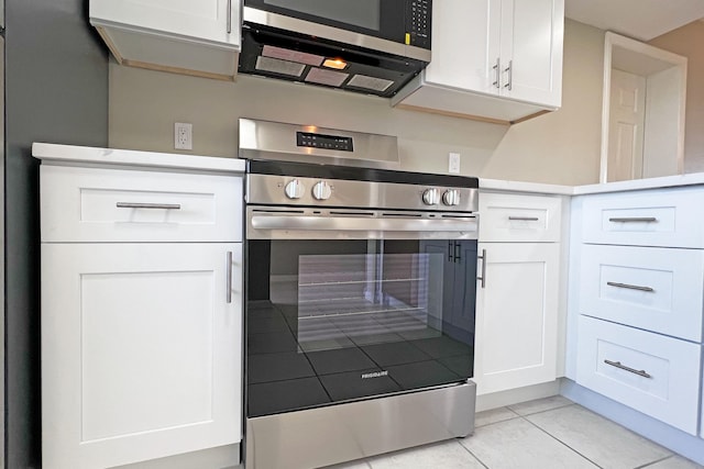 3636 Whitehall Dr Unit 402A, West Palm Beach, FL 33401 - kitchen with appliances with stainless steel finishes, white cabinetry, light tile patterned floors, and light countertops