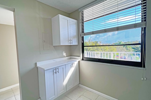 3636 Whitehall Dr Unit 402A, West Palm Beach, FL 33401 - kitchen with baseboards, light tile patterned floors, white cabinetry, and a textured ceiling
