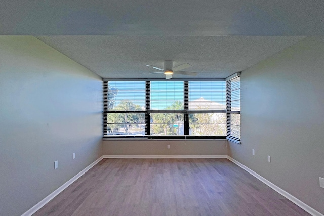 3636 Whitehall Dr Unit 402A, West Palm Beach, FL 33401 - unfurnished room with wood finished floors, ceiling fan, baseboards, and a textured ceiling