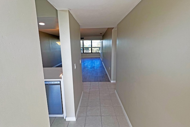 corridor with baseboards and light tile patterned floors