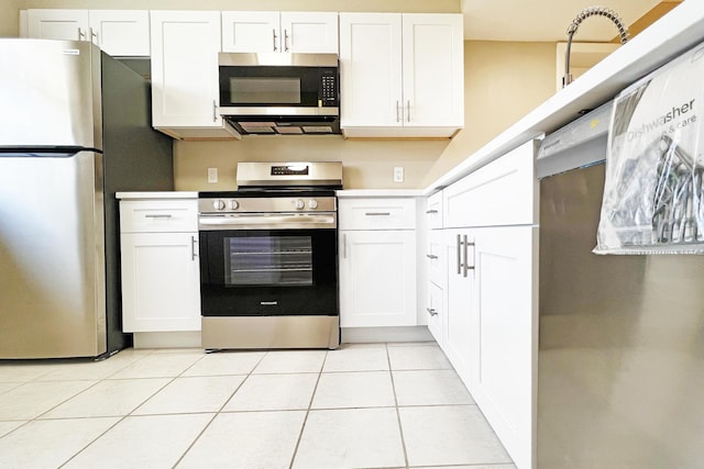3636 Whitehall Dr Unit 402A, West Palm Beach, FL 33401 - kitchen with appliances with stainless steel finishes, white cabinets, light tile patterned flooring, and light countertops