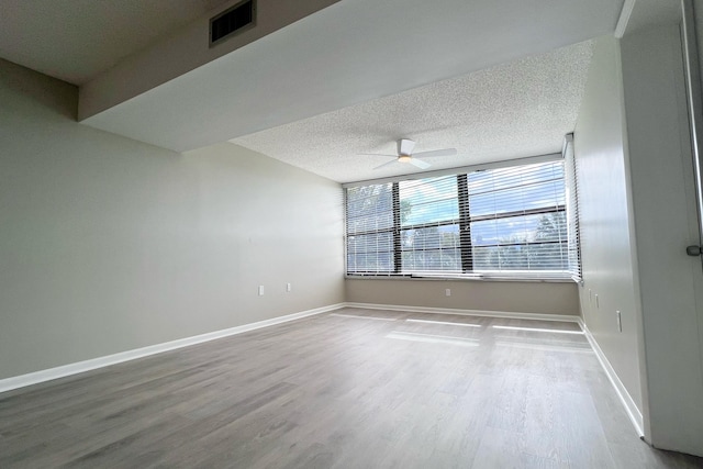 3636 Whitehall Dr Unit 402A, West Palm Beach, FL 33401 - empty room with wood finished floors, baseboards, a ceiling fan, and a textured ceiling