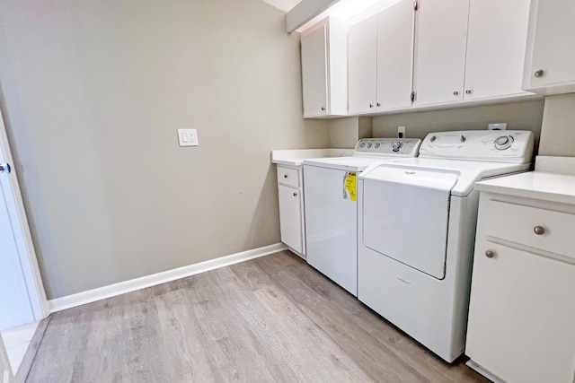 3636 Whitehall Dr Unit 402A, West Palm Beach, FL 33401 - washroom featuring cabinet space, washer and dryer, light wood-style flooring, and baseboards