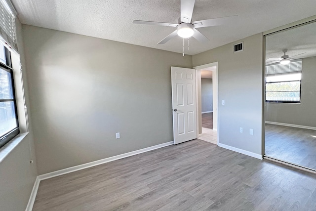 3636 Whitehall Dr Unit 402A, West Palm Beach, FL 33401 - unfurnished bedroom featuring wood finished floors, a closet, baseboards, a ceiling fan, and a textured ceiling