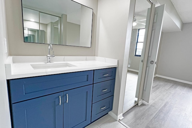 3636 Whitehall Dr Unit 402A, West Palm Beach, FL 33401 - bathroom featuring wood finished floors, vanity, baseboards, and a ceiling fan