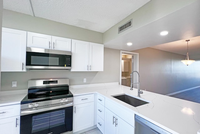 3636 Whitehall Dr Unit 402A, West Palm Beach, FL 33401 - kitchen with stainless steel appliances, a sink, white cabinetry, light stone counters, and decorative light fixtures