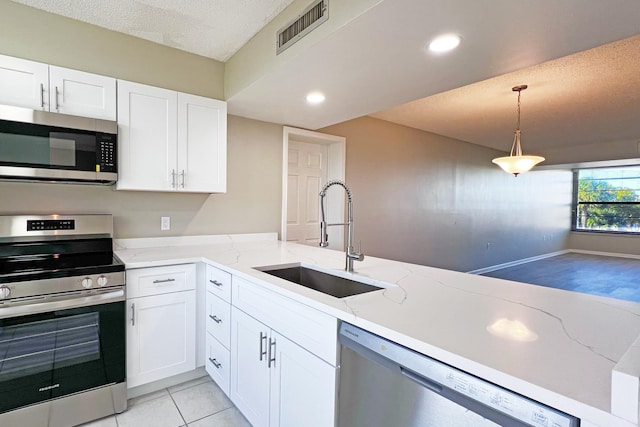 3636 Whitehall Dr Unit 402A, West Palm Beach, FL 33401 - kitchen with stainless steel appliances, a sink, white cabinetry, recessed lighting, and a textured ceiling