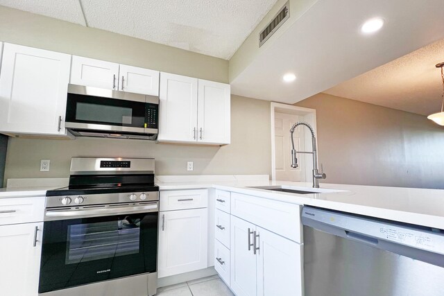 3636 Whitehall Dr Unit 402A, West Palm Beach, FL 33401 - kitchen with stainless steel appliances, a sink, light countertops, white cabinets, and a textured ceiling