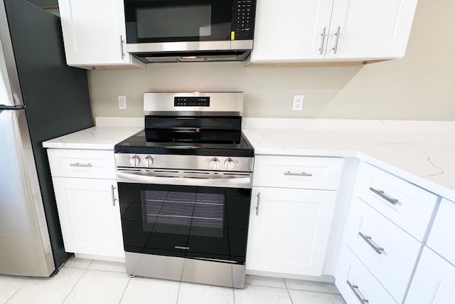 3636 Whitehall Dr Unit 402A, West Palm Beach, FL 33401 - kitchen featuring stainless steel appliances, white cabinetry, light tile patterned floors, and light stone counters