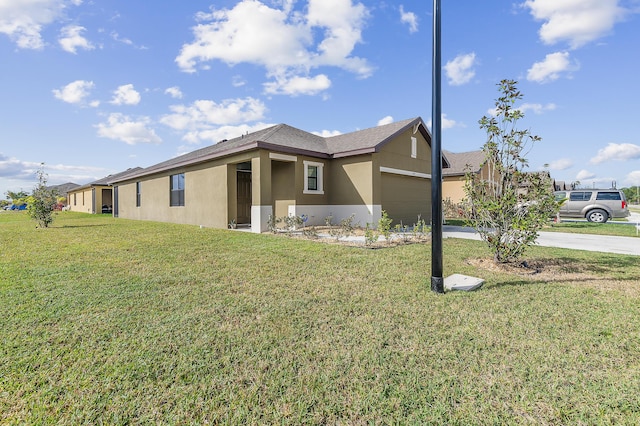 exterior space featuring an attached garage, concrete driveway, a front yard, and stucco siding