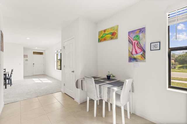 dining area featuring light tile patterned floors, a wealth of natural light, and light colored carpet