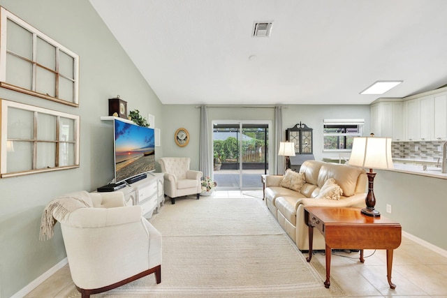 living area with light tile patterned floors, visible vents, and baseboards