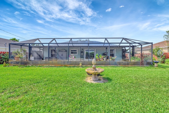 back of house with glass enclosure and a lawn