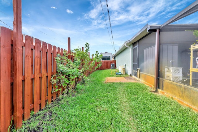 view of yard featuring a fenced backyard and central AC