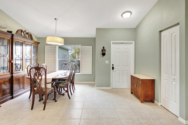 dining space featuring light tile patterned flooring and baseboards